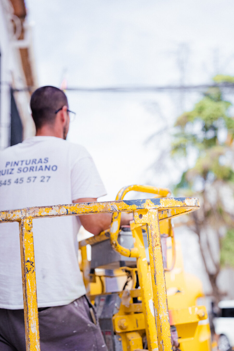 Operario trabajando en altura con plataforma Alquimar — pintura de fachada